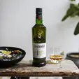 Бутилка 12-годишно скоч уиски Glenfiddich 1 л. върху маса с 1 чаша с уиски